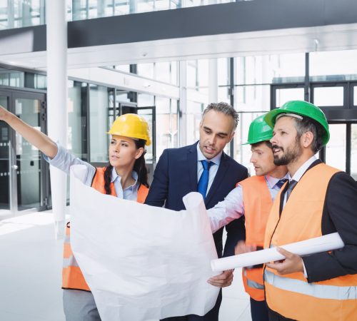 Businessman discussing on blueprint with architects in office building